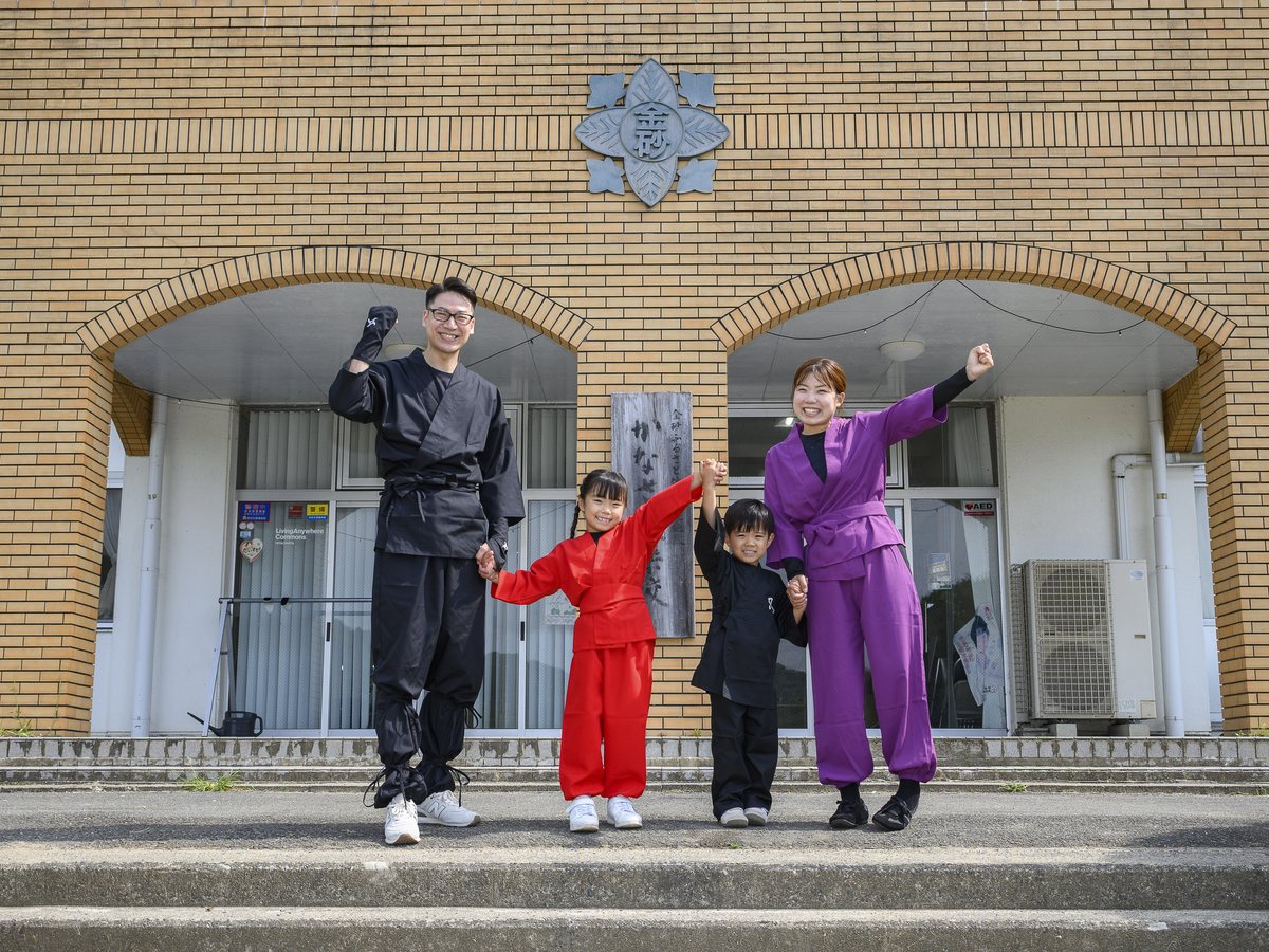 かなさ笑楽校の玄関前に立つ忍者衣装の家族