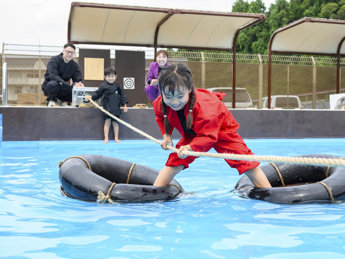 水蜘蛛に挑戦する赤い忍者衣装の子ども