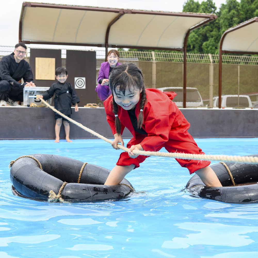 水蜘蛛に挑戦する赤い忍者衣装の子ども